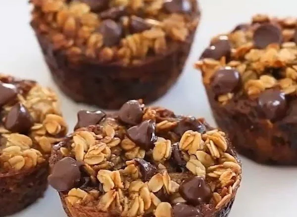 Healthy banana chocolate chip oatmeal muffins with chocolate chips on a wooden table