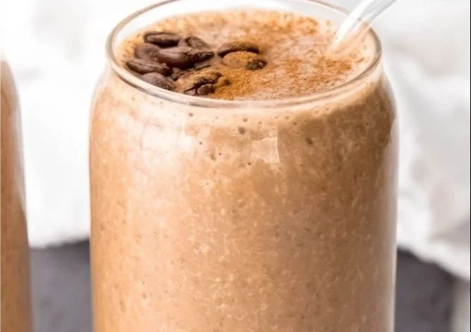 Cold brew coffee protein smoothie topped with fresh fruits and nuts.