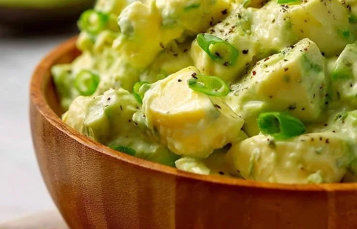 High-protein avocado egg salad in a green bowl garnished with herbs