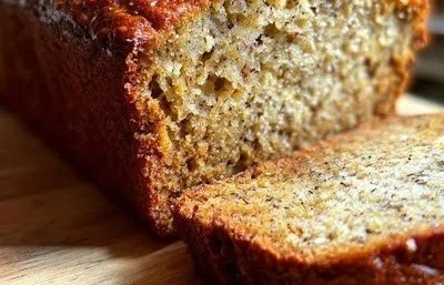 High-Protein Banana Bread 5 High-protein banana bread loaf with walnuts on a wooden table